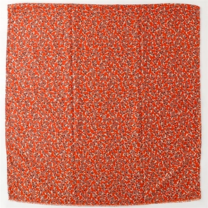 Detailed view of red floral scarf with leaf pattern and delicate frayed edge texture