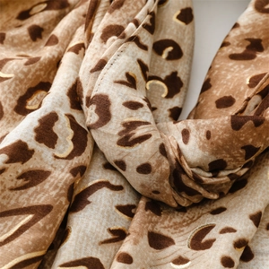 Detailed view of leopard print scarf fabric with premium gold foil sketching accents