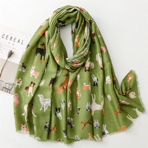 Detail of green linen scarf with cute cartoon dog patterns and soft tassel edges