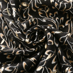 Macro view of cotton linen scarf with gold foil creeping vine pattern and soft texture