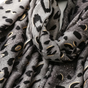 Close-up of leopard print scarf with gold foil details and soft cotton linen texture
