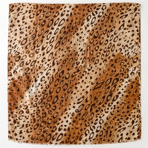 Detail of leopard print scarf with gold foil accents and soft frayed edge texture
