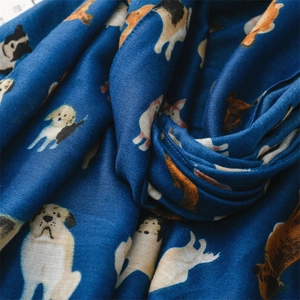 Detail showing soft cotton-linen fabric texture with cute cartoon dog prints on dark blue scarf
