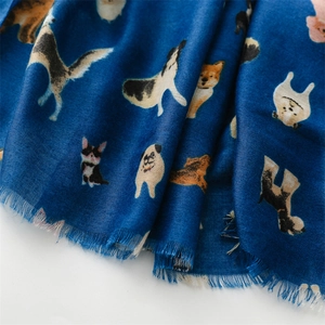 Detail of dark blue scarf with cute cartoon dog patterns and frayed tassel edges