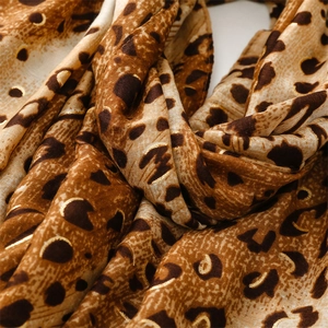 Macro shot of leopard print scarf featuring gold foil details on soft textured fabric