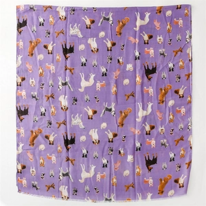 Detailed view of purple scarf featuring colorful cartoon dog prints and fringe edges