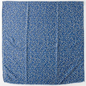 Detail of royal blue scarf with gold foil plant patterns and frayed tassel edges