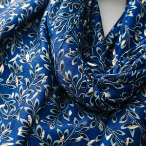 Close-up of navy cotton linen scarf with elegant gold leaf foil pattern texture