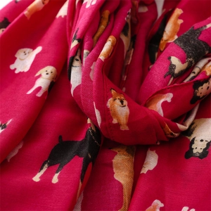 Detailed view of soft cotton-linen feel scarf with vibrant cartoon dog patterns in red