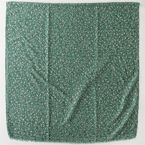 Detail of green cotton linen scarf with cream climbing plant patterns and fringed edges