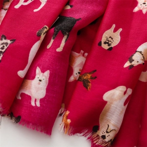 Detail of rose red cotton linen scarf featuring cartoon dog prints and frayed edges