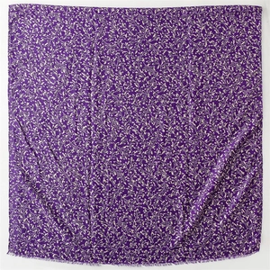 Detail of purple scarf with botanical gold foliage pattern and soft fringe edges
