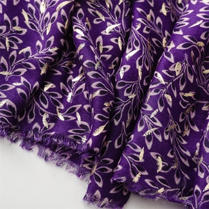 Close-up of purple linen-feel scarf with gold foil ivy leaf pattern and fringe detail