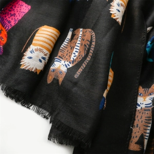 Close-up of black scarf with cartoon cat prints and natural frayed edges texture