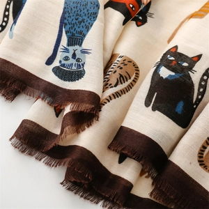 Detail view of cotton linen scarf featuring colorful cartoon cat prints and fringe edges