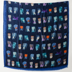 Detailed view of dark blue scarf with colorful cartoon cat patterns and fringe edges