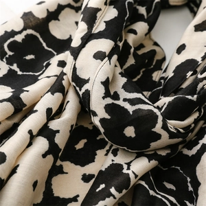 Close-up of black floral print scarf showing soft texture and high-quality weave