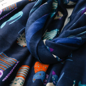Detail of soft navy blue cotton linen scarf featuring colorful cartoon cat patterns