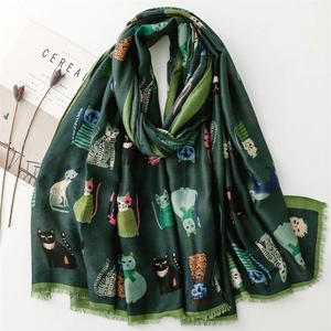 Detailed view of deep green cotton-linen scarf with artistic cartoon cat prints and fringe
