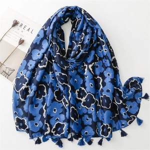 Detail of dark blue floral cotton scarf with fringe tassels on white background