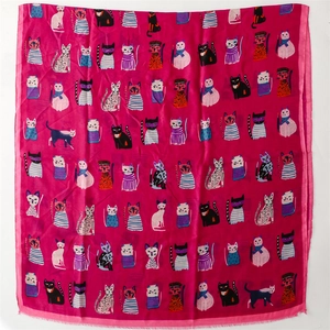 Close-up of pink silk scarf featuring cartoon cat illustrations and fine hemmed edges
