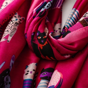 Detailed close-up of cartoon cat print and soft texture on pink cotton linen scarf