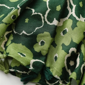 Detail of floral pattern on green cotton linen feel scarf with tassel edge trim