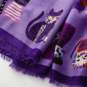 Detailed close-up of vibrant purple scarf with cartoon cat prints and fringe edges