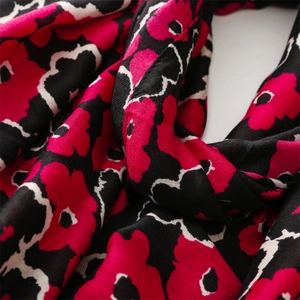 Macro view of floral print linen-feel scarf showing weaving texture and fine stitching