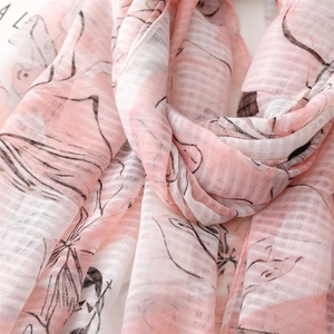 Detail eines rosa floralen Baumwoll-Leinen-Schals mit weicher Textur und Fransen-Quasten