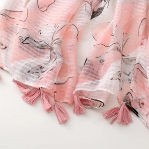 Detailaufnahme von rosa Baumwoll-Leinen-Schal mit Blumendrucken und Fransenquasten