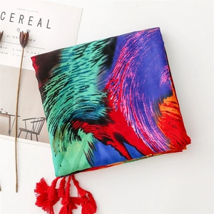 Detail of colorful peacock feather print scarf with red tassels and twill texture