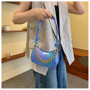 Close-up of iridescent blue-purple gradient shoulder bag with chunky gold chain detail