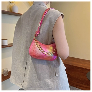 Detail of metallic pink half-moon bag with scaly texture and chunky gold chain strap