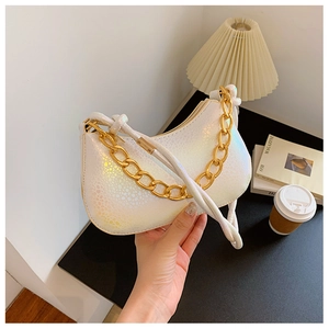 Detail of white iridescent crescent bag with laser scales and chunky gold chain handle