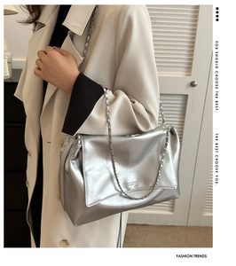 Détail du sac hobo argenté métallisé avec bandoulière chaîne porté par un mannequin