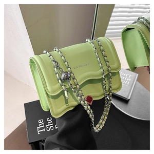 Detail of light green crossbody bag with gold ball buckle and chain strap adjustment