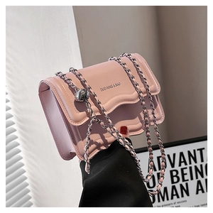 Detailed view of pink leather bag with scalloped flap and silver spherical metal buckle