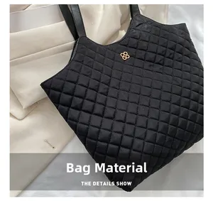Macro shot of black quilted nylon tote bag with golden petal logo and diamond stitching