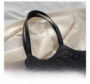 Detail showing comfortable black straps and quilted nylon texture of the tote bag