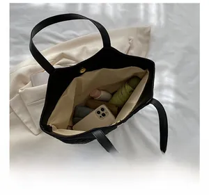 Internal view of black quilted tote bag showing large capacity for daily essentials