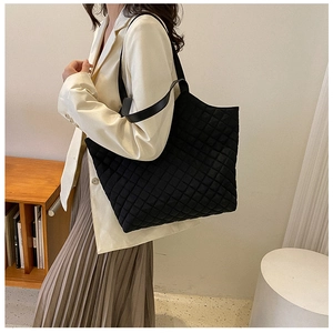 Detail of black quilted tote bag showing fine stitching and premium nylon texture