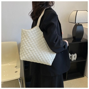 Close-up of beige quilted tote bag with diamond stitching pattern on premium matte leather