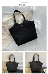Detail of black quilted tote bag featuring golden clover logo and stitched texture