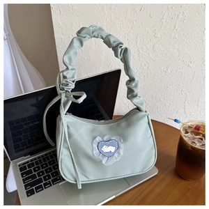 Détail du sac à main en nylon vert clair avec broderie lapin cœur et poignée volantée