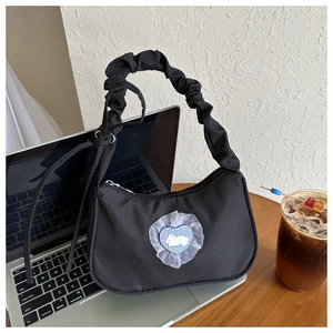 Détail du sac noir avec anses froncées et écusson mignon en forme de cœur lapin