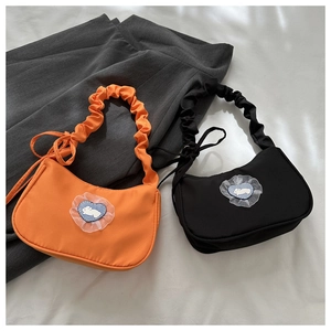 Détail de sacs demi-lune aux couleurs bonbon avec patchs lapin cœur et bandoulières froncées