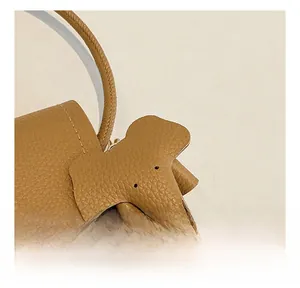 Close-up of brown pebbled leather crossbody bag with cute elephant charm detail