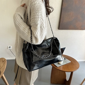 Sac fourre-tout minimaliste en cuir noir brillant avec bandoulière chaîne en argent chic