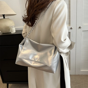 Sac fourre-tout en cuir métallisé argenté avec bandoulière chaîne en intérieur moderne